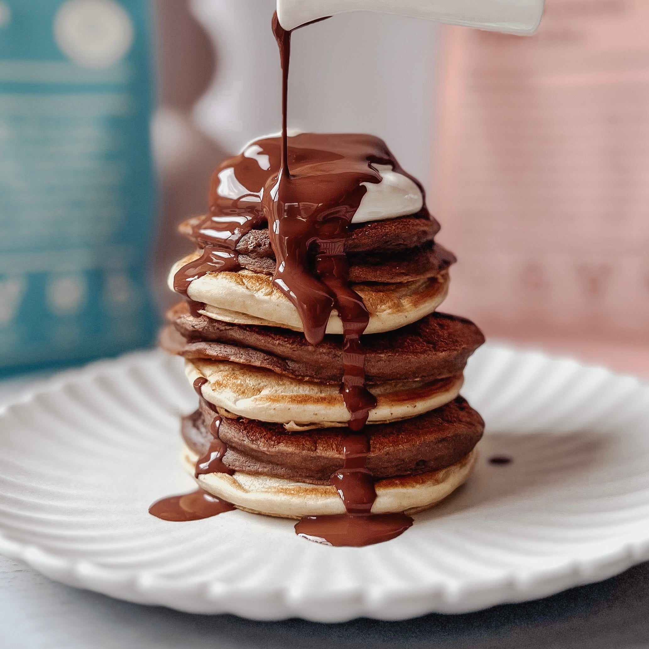 chocolate and vanilla protein pancake stack with chocolate sauce