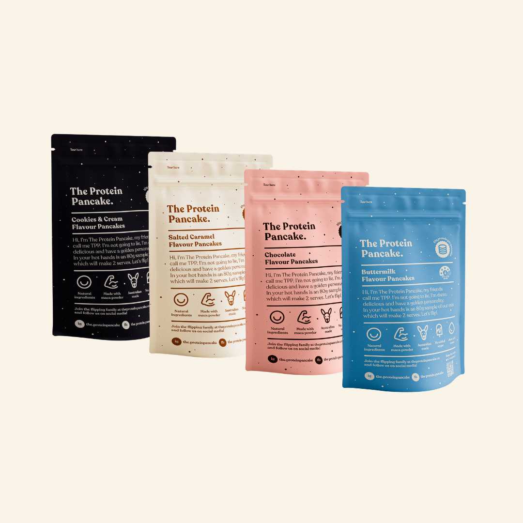 Three colorful packets of The Protein Pancake mix in different flavors.